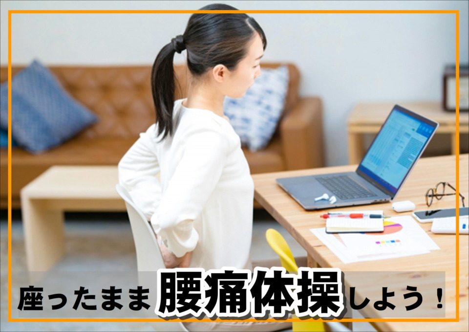 腰痛に悩む女性がデスクワーク中に腰を気にしている様子