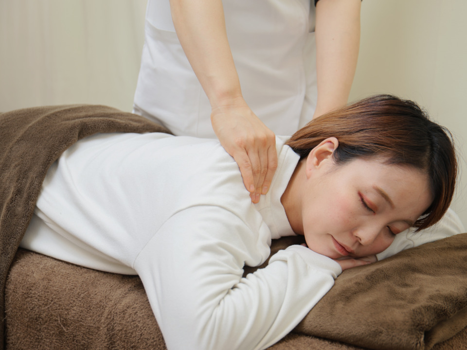 肩こり緩和のためのマッサージ施術を受ける女性