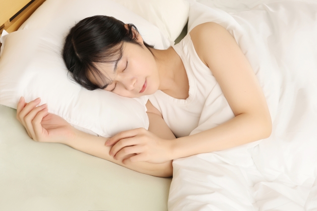 寝返りをうちながら快眠している女性の写真